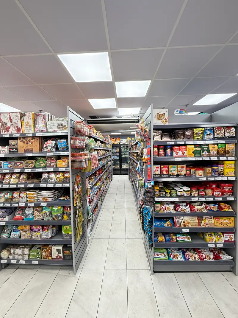 A long aisle of biscuits, sweets, Turkish delight and coffee on grey shelving