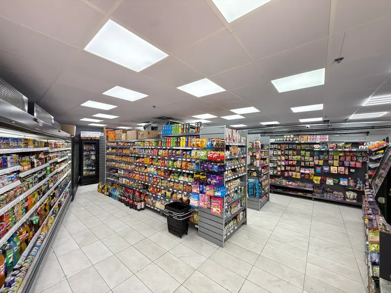 A shop floor with a chilled drinks fridge, snack aisles and confectionery
