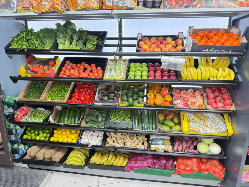 A wall of fresh fruit and vegetables including herbs, tomatoes, peppers, bananas, apples, oranges, ginger and avocados