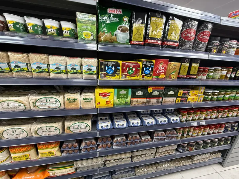 Shelves of black, green and fruit teas, with eggs, semolina and jarred pickles below